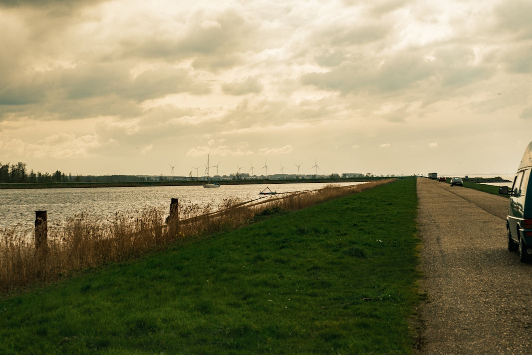 a van parked on the side of a road next to a body of water