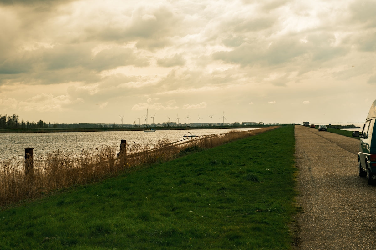 a van parked on the side of a road next to a body of water
