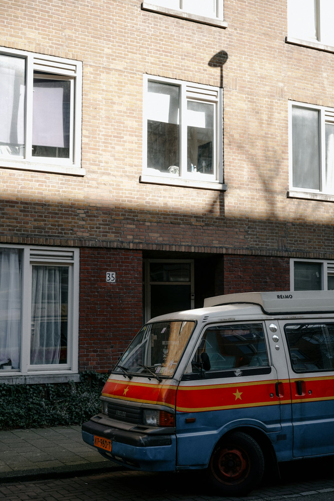 A colorful van is parked in front of a building.