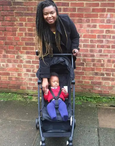 Black stroller with a baby seated inside